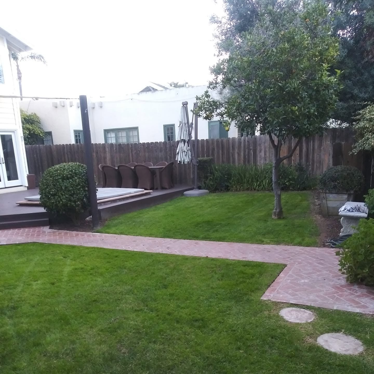 Lush green lawn with brick paver walkway by A.G Landscape